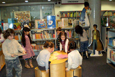 Imagen de la sala infantil de la biblioteca con niños leyendo
